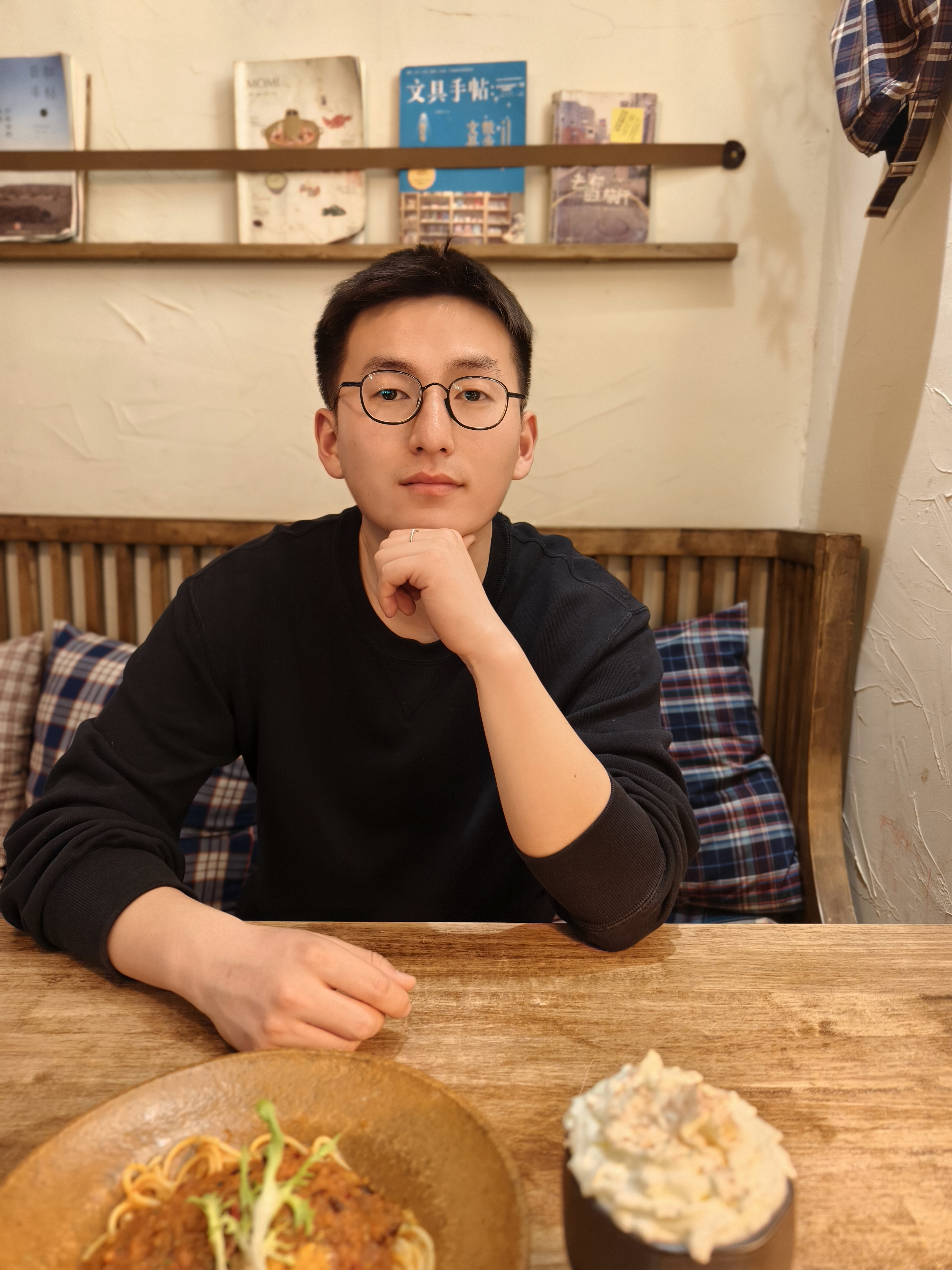 朱彼得坐在木桌前的个人照片